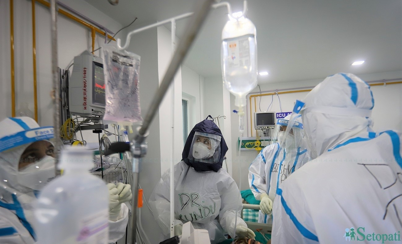 Dr Kundu Shrestha and fellow medics attending to a patient at the ICU ward.