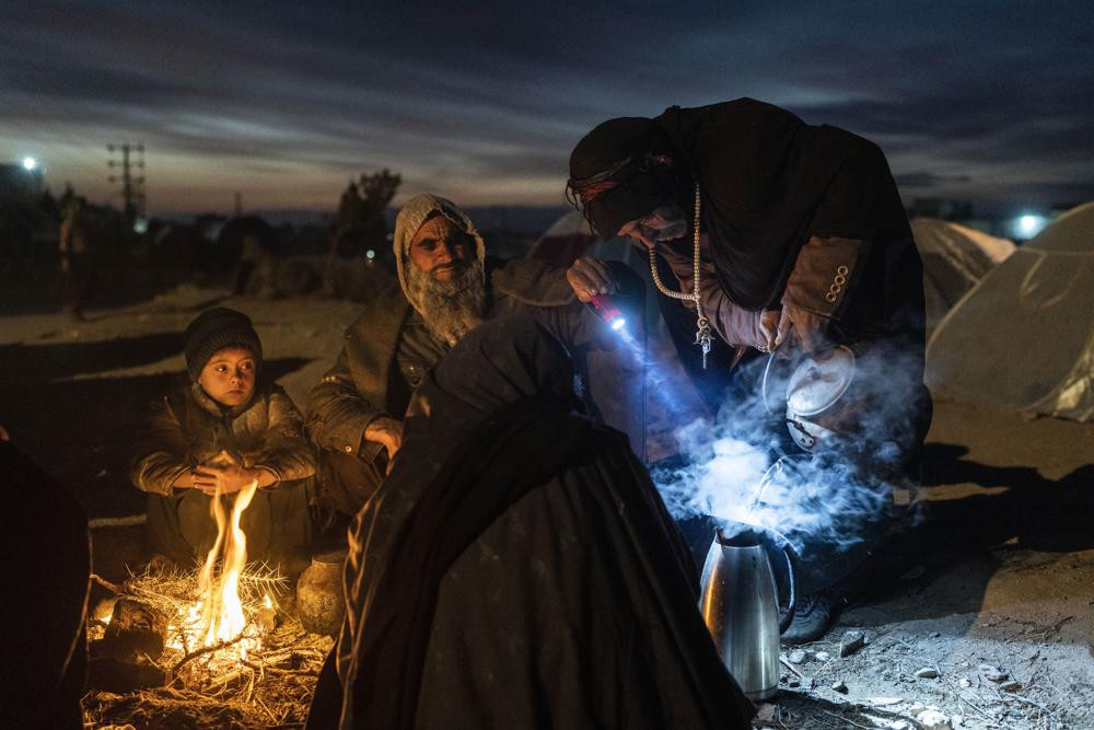 A family prepares tea outside the Directorate of Disaster office where they are camped, in Herat, Afghanistan, on Nov. 29, 2021.