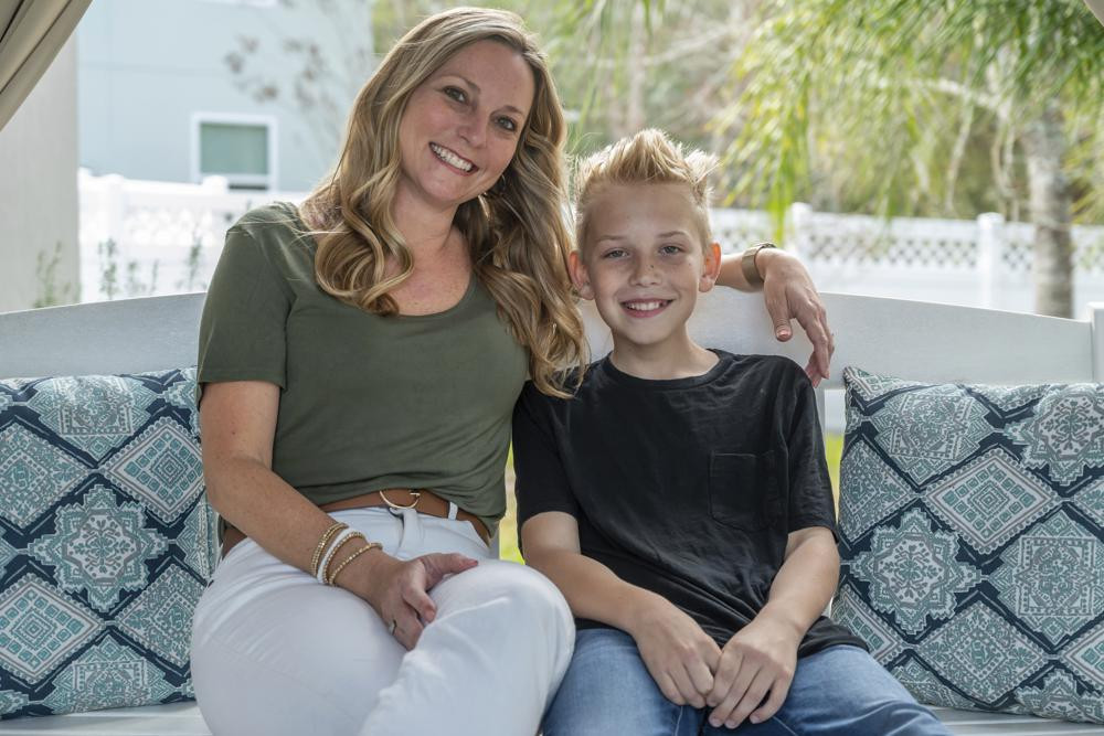 Holly Nover sits with her son, Colton Nover, 10, on a backyard swing at their home Wednesday, Feb. 16, 2022, in St. Johns, Florida.
