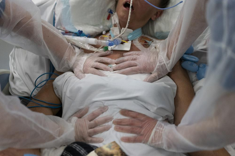 Nurses perform timed breathing exercises on a COVID-19 patient on a ventilator in the COVID-19 intensive care unit at the la Timone hospital in Marseille, southern France, Friday, Dec. 31, 20