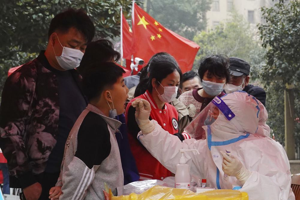 A medical worker takes a swab sample from a child for Covid-19 testing in a community in Changzhou in eastern China's Jiangsu province Monday, March 14, 2022.