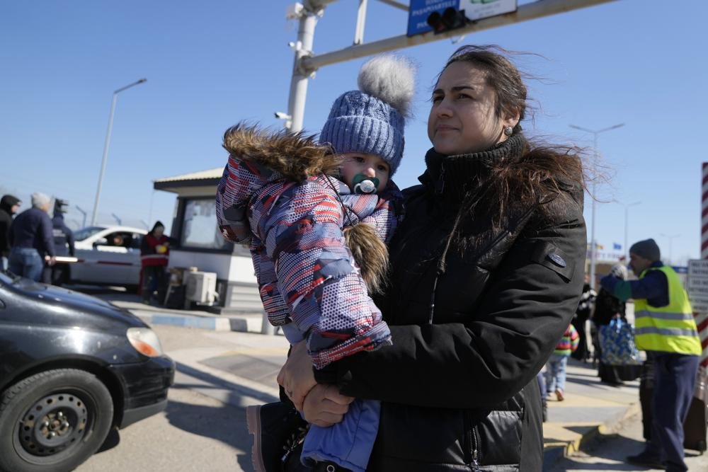 A woman carries her baby after fleeing the war from neighbouring Ukraine at the border crossing in Palanca, Moldova, Saturday, March 19, 2022.