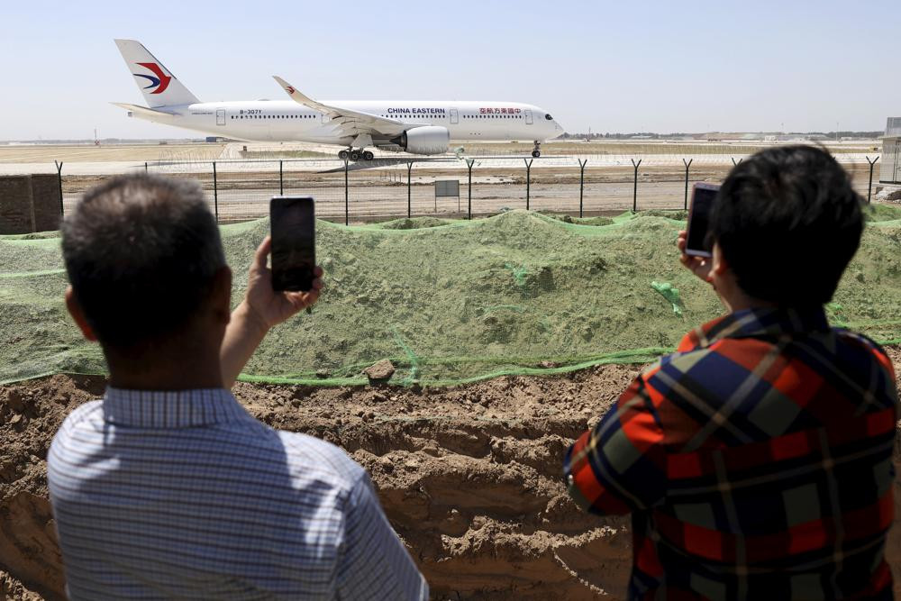 Residents watch as a China Eastern passenger jet prepares to take off on a test flight from the new Beijing Daxing International Airport on Monday, May 13, 2019.