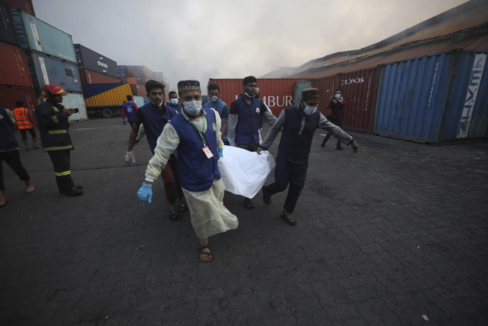People carry the body of a victim after a fire broke out at the BM Inland Container Depot, a Dutch-Bangladesh joint venture, in Chittagong, 216 kilometers (134 miles) southeast of capital, Dh