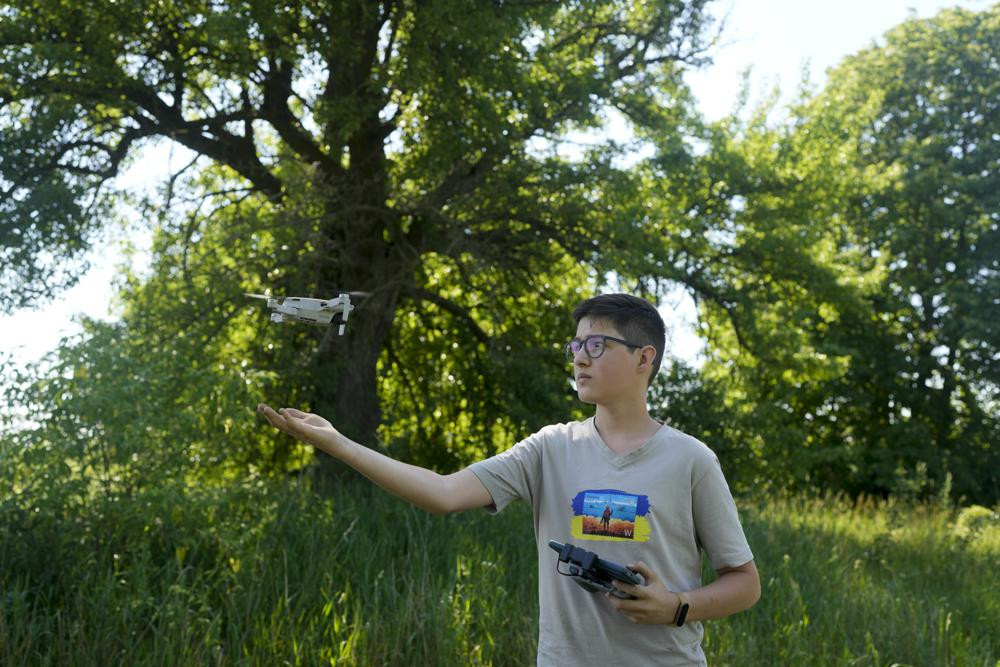 Andriy Pokrasa, 15, lands his drone on his hand during an interview with The Associated Press in Kyiv, Ukraine, Saturday, June 11, 2022.