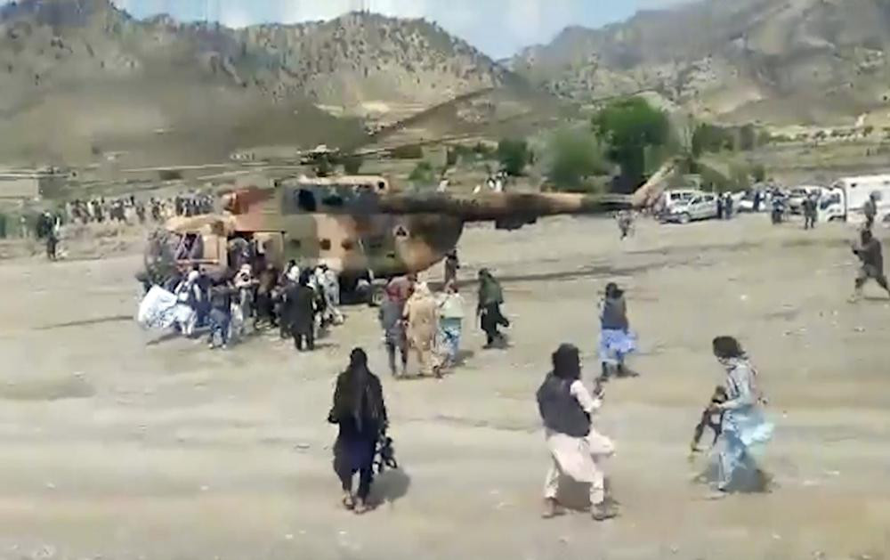 In this image taken from video from Bakhtar State News Agency, Taliban fighters secure a government helicopter to evacuate injured people in Gayan district, Paktika province, Afghanistan, Wed