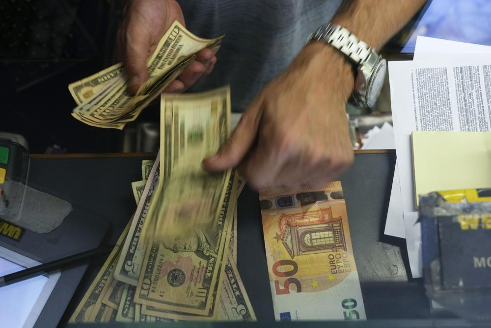 FILE - A cashier changes a 50 Euro banknote with US dollars at an exchange counter in Rome, Wednesday, July 13, 2022.  AP/RSS Photo