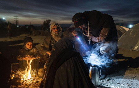 A family prepares tea outside the Directorate of Disaster office where they are camped, in Herat, Afghanistan, on Nov. 29, 2021.