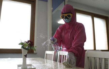 FILE - An employee of Pyongyang Dental Hygiene Products Factory disinfects the floor of a dinning room as the state increased measures to stop the spread of illness in Pyongyang, North Korea,