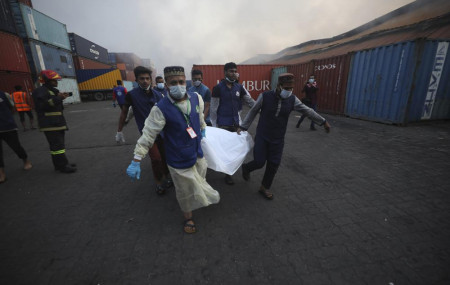 People carry the body of a victim after a fire broke out at the BM Inland Container Depot, a Dutch-Bangladesh joint venture, in Chittagong, 216 kilometers (134 miles) southeast of capital, Dh