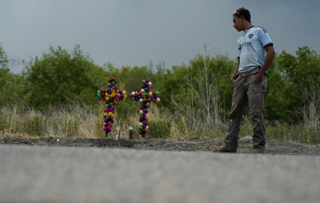 A man pays his respects at the site where officials found dozens of people dead in a semitrailer containing suspected migrants, Tuesday, June 28, 2022, in San Antonio. AP/RSS Photo