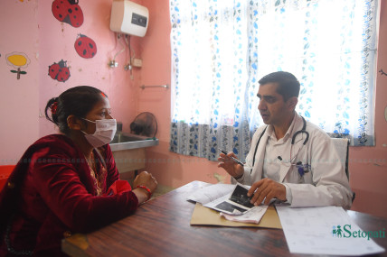 परोपकार प्रसूति गृहका निर्देशक एवं स्त्री तथा प्रसूति रोग विशेषज्ञ डा. श्रीप्रसाद अधिकारी सेवाग्राहीसँग कुरा गर्दै। तस्बिरः निशा भण्डारी/सेतोपाटी