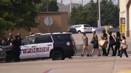 People raise their hands as they leave a shopping center following reports of a shooting, Saturday, May 6, 2023, in Allen, Texas. AP/RSS Photo