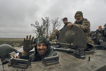 A Ukrainian soldier smiles from a military vehicle on the road in the freed territory in the Kharkiv region, Ukraine, Monday, Sept. 12, 2022. AP/RSS Photo