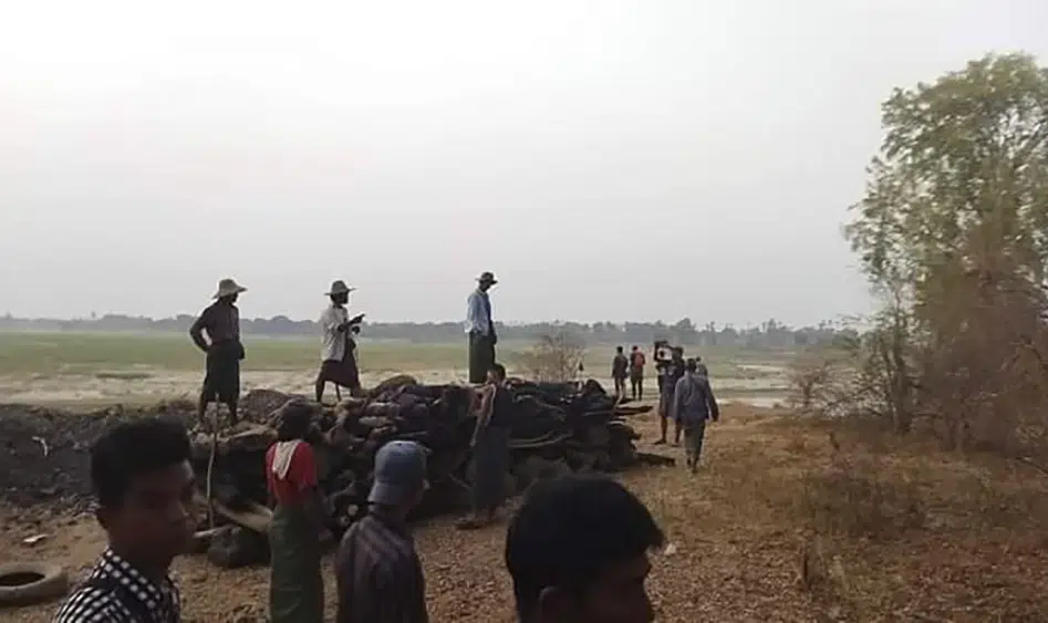 Men stand over a funeral pyre in Tar Taing village, as they prepare to cremate bodies of those found dead in the nearby village of Nyaung Yin, Myinmu township and in Tar Taing village, Sagaing township, central Myanmar on Thursday, March 2, 2023. AP/RSS Photo