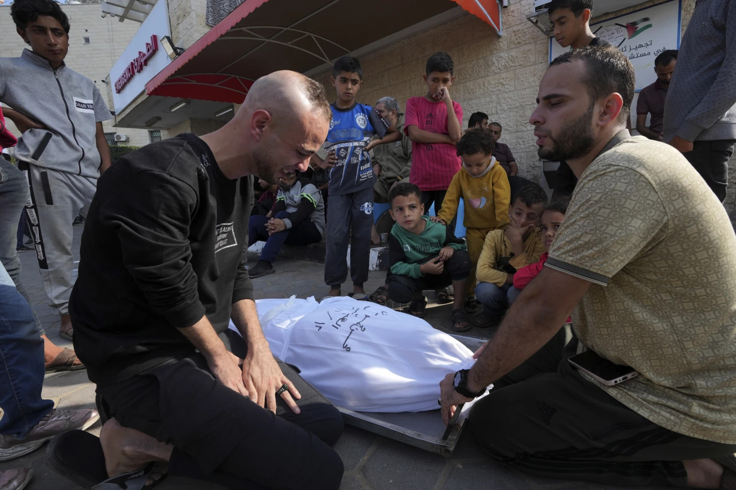 Palestinians mourn over the body of their father, Mohsem al Hegi, who was killed in the Israeli bombardment of the Gaza Strip, in front of the morgue of al Aqsa Hospital in Deir al Balah, Gaza Strip, Monday, Nov. 13, 2023. (AP/RSS Photo)