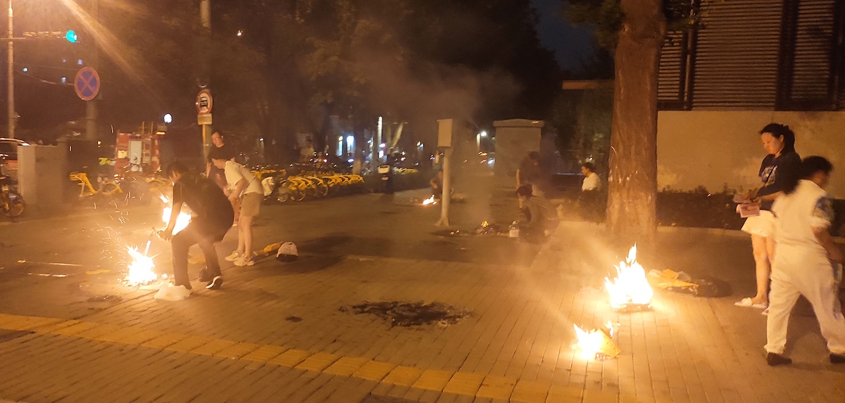 बेइजिङको व्यस्त चौबाटोमा पितृको सम्झनामा आगो बालेर पैसा डढाउँदै। तस्बिरः चेतनाथ आचार्य