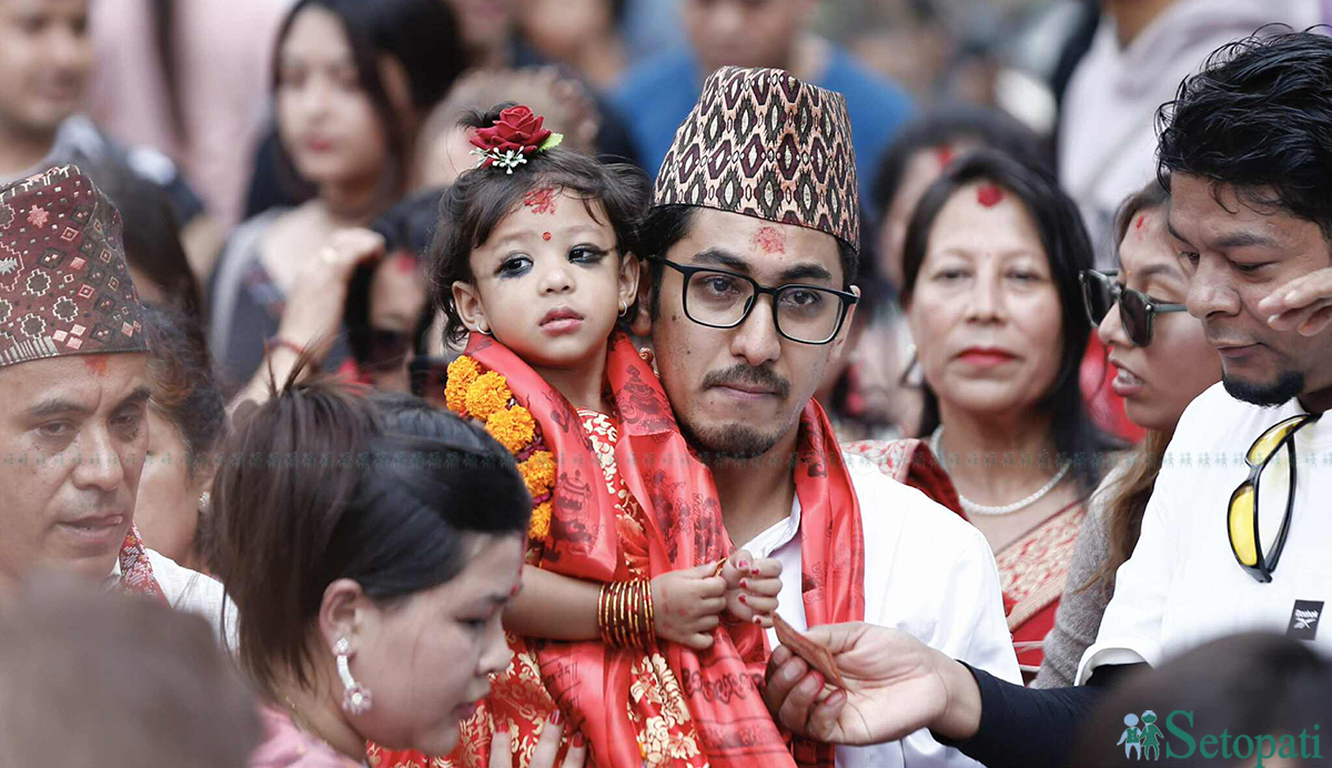 नवघोषित कुमारी आर्यतारा शाक्यलाई काँधमा बोकेर कुमारी घर लैजाँदै उनका बुबा अनन्त शाक्य। तस्बिर: नवीनबाबु गुरूङ/सेतोपाटी