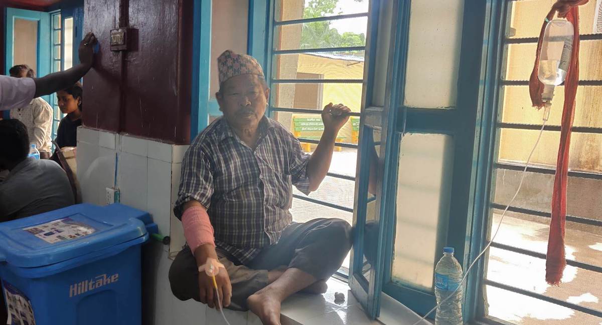 सर्पले टोकेर उपचारका लागि कोशी अस्पताल पुगेका ७० वर्षे  हेमराज मगरलाई झ्यालमा राखेर उपचार गराउँदै। तस्बिर: राजु अधिकारी/ सेतोपाटी