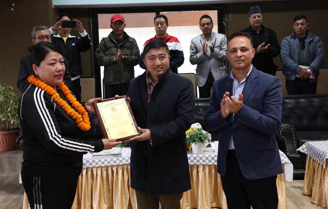 सदस्य–सचिव टंकलाल घिसिङ (बीच) सविता राजभण्डारीलाई प्रशंसा पत्र प्रदान गर्दै ।